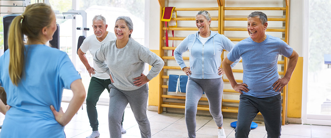 A group of seniors being led in exercises by an instructor.